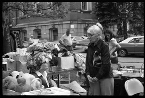 Older woman looking over goods at the Unitarian Society tag sale, Northampton