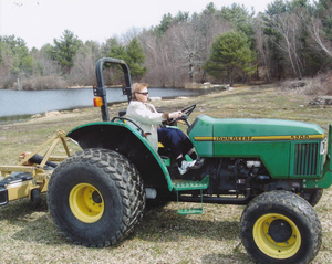 Mary Wilson on the John Deere tractor on the farm