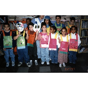 Children wearing masks and costumes made from paper and glitter.