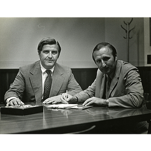 Frederick J. Davis, at left, and John Whelam signing papers at a Boys' Club meeting