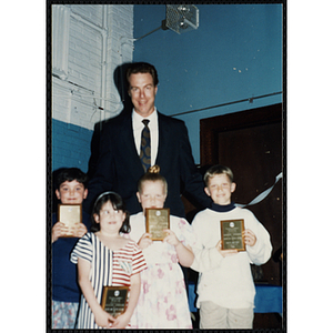 Former Boston Celtic Dave Cowens posing for a group picture with four boys and girls at a Kiwanis Awards Night