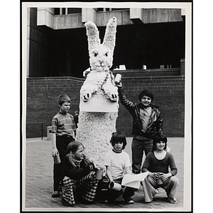 Five boys and girls from the Boys' Clubs of Boston posing with their art project: a rabbit statue holding a sign with the text "SUPPORT OUR [?]"