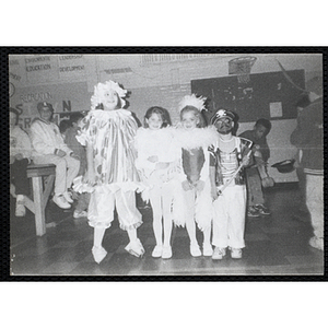 Four children pose in their costumes at a Halloween party