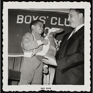 The Kiwanis Club's president Les Oshry presents a boy with a bunny figurine at a birthday party