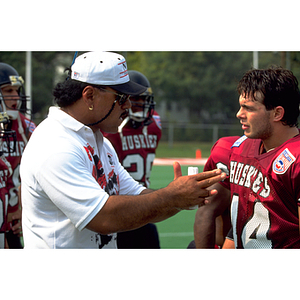 Football coach speaking to a player during a practice