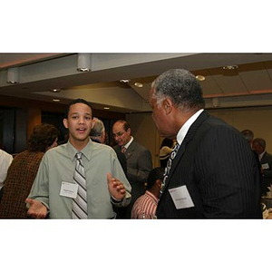 Odalis David Polanco converses with a man at the Torch Scholars dinner