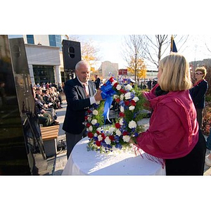 A man and woman hold a wreath at the Veterans Memorial dedication ceremony