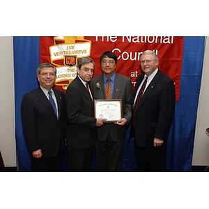 Homer Pien poses with his certificate and three men at the National Council Dinner