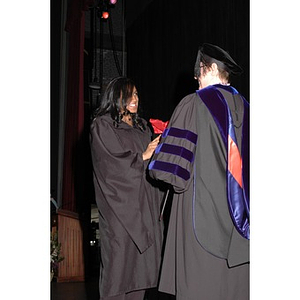 Faculty member presents student with gift bag at School of Nursing convocation