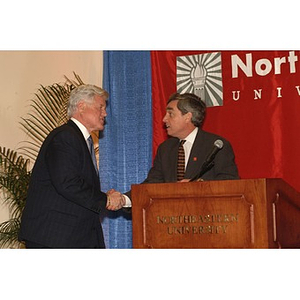 Senator Kennedy and Richard Freeland shake hands at press conference on student financial aid cuts