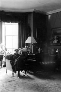 Portrait of an unidentified woman, seated on a chair in the second floor parlor, facing front, reading a newspaper, Greely Stevenson Curtis House, 28-30 Mount Vernon St., Boston, Mass., February 18, 1923