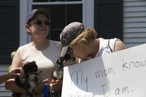 Pro-immigration protesters and their dogs outside the Chatham town offices building with sign reading 'My mom knows where I am, shouldn't theirs?' : taken at the 'Families Belong Together' protest against the Trump administration's immigration policies