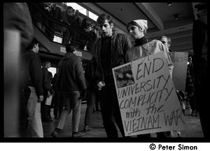 Demonstration against Marine recruiters: protester carrying sign reading 'End university compicity with the Vietnam War'