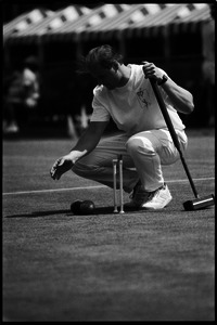 Croquet player kneeling to line up a shot, Newport, R.I.