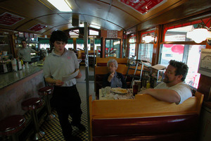 Waiter and diners at a booth at the Miss Florence Diner