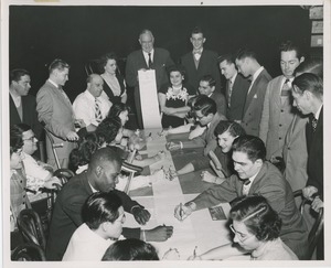 Large group of men and women participating in the signing of the scroll