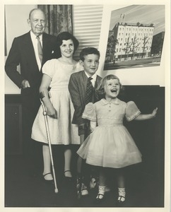 Jeremiah Milbank Sr. with three young ICD clients in front of an illustration of prospective building plans