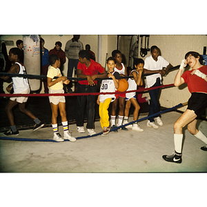 Group of boys watching a man in a boxing ring