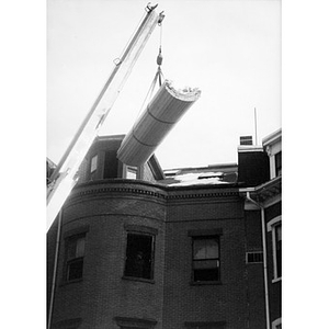 Crane lifting building supplies to the top floor window of 326 Shawmut Avenue.