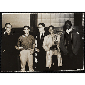 Richard B. K. McLanathan, at center, posing with four men holding their basketball tournament trophies