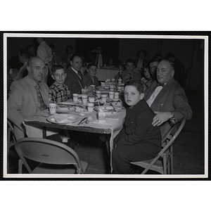 Men and boys sit at a table during a Dad's Club banquet