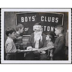 Four boys accept gifts from Santa Claus