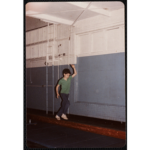 A boy walks across a balance beam at the Charlestown gymnasium