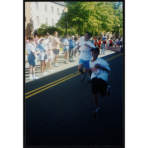 Two boys run by spectators during the Battle of Bunker Hill Road Race