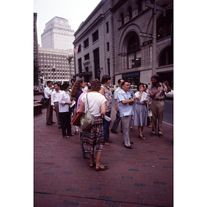 Visitors from China stand at the corner of Washington and Court Streets on a tour of Boston