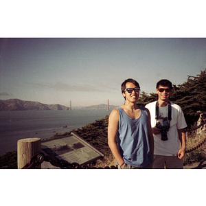 Two Association members stand on a hiking path near the ocean in San Francisco, California, with the Golden Gate Bridge in the background