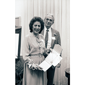 George and Ellen Kariotis holding a necklace at the Kariotis Hall dedication