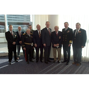 Nine men pose together at the Veterans Memorial dedication ceremony
