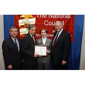 Mary Ryan poses with her certificate and three men at the National Council Dinner