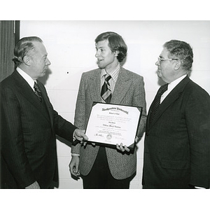 William Aldrich Hutchins, graduate of the School of Law, receiving diploma from President Kenneth G. Ryder, left, and Dean John O'Bryne, right