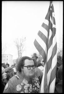 Protester with an American flag, decked out in antiwar buttons, during a demonstration against the invasion of Laos