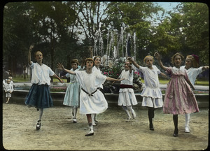 Girls dancing by a water fountain in a park