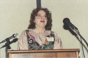 Judi Chamberlin speaking behind podium