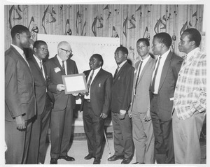 Hugh Thompson presents certificates to seven unidentified students of the International Agricultural Training Program