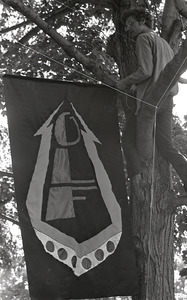 Gay liberation demonstration at Cambridge Common: man hanging Gay Liberation Front flag