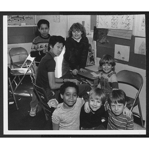 Children posing around desk