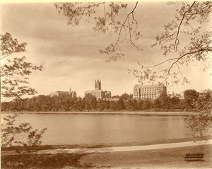 Devlin Hall, Gasson Hall, and Saint Mary's Hall from reservoir, with path and bench, by Clifton Church