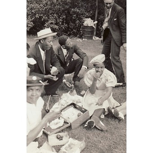A group of men and women enjoy a picnic in the park