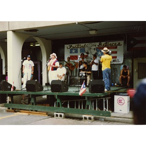 Musicians performing on a makeshift stage at a rainy Festival Betances.