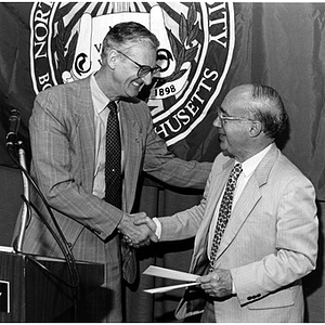 Former Lane Health Center psychiatrist Bernard Stotsky, right, presents a Holocaust Memorial Award to graduate student Spencer Blakeslee at President's breakfast during Holocaust Remembrance Week at NU (NU Voice), 1993.