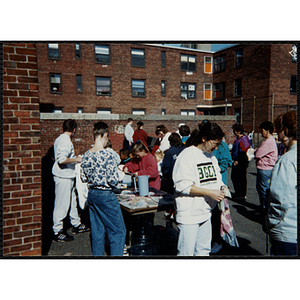 People surround a tie-dye activity table at a carnival