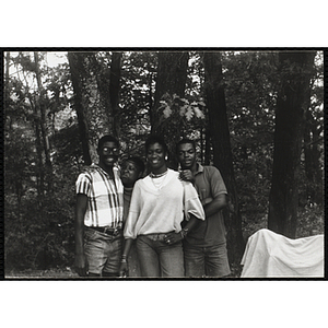 A Group of four youth standing in front of trees