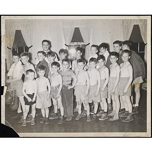 Two rows of boys pose for a photograph with their boxing instructor