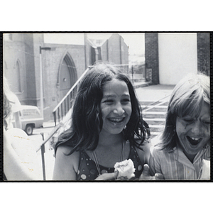 Two girls with painted faces laugh while eating outside the Charlestown Boys & Girls Clubhouse