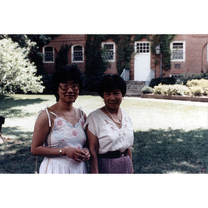 Suzanne Lee and another woman stand in a grassy field during a formal event