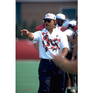 Football coach gestures at the field during practice